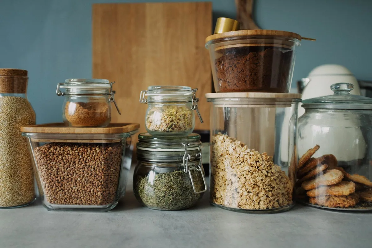 Potes com alimentos organizados em uma prateleira.
