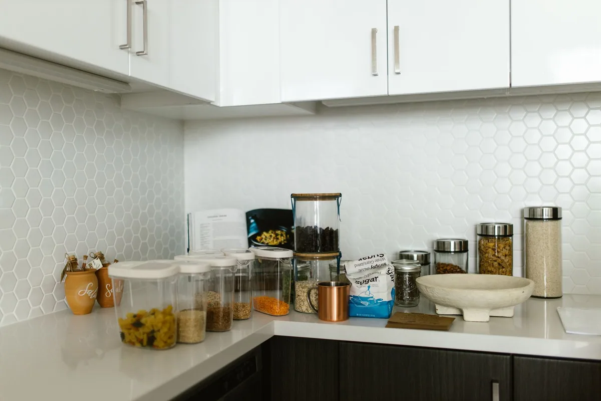 Potes e recipientes de alimentos em uma bancada de cozinha.